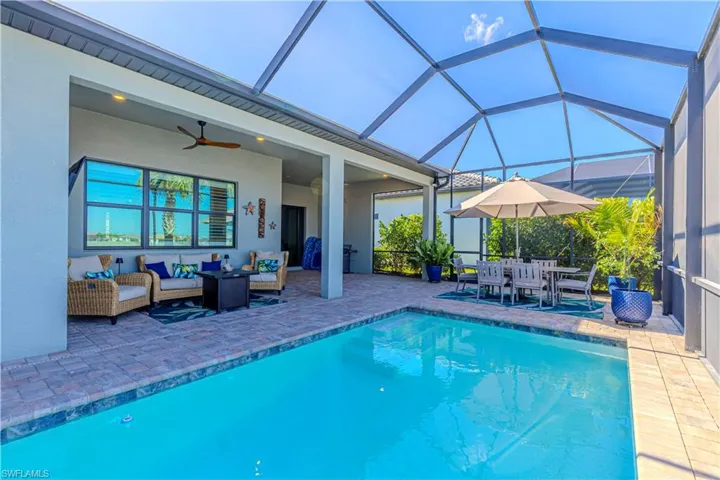 Outdoor pool featuring outdoor lounge area, a ceiling fan, glass enclosure, a patio, and outdoor dining area