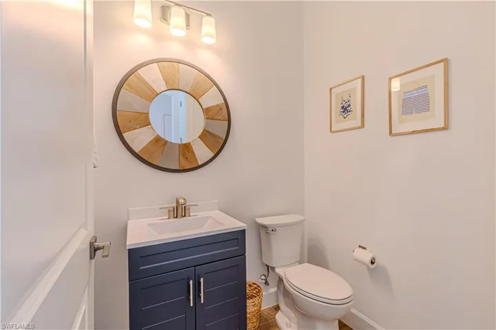 Half bath with toilet, vanity, and baseboards