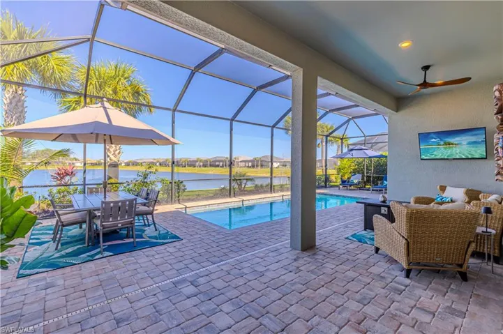 Pool featuring ceiling fan, glass enclosure, and a patio
