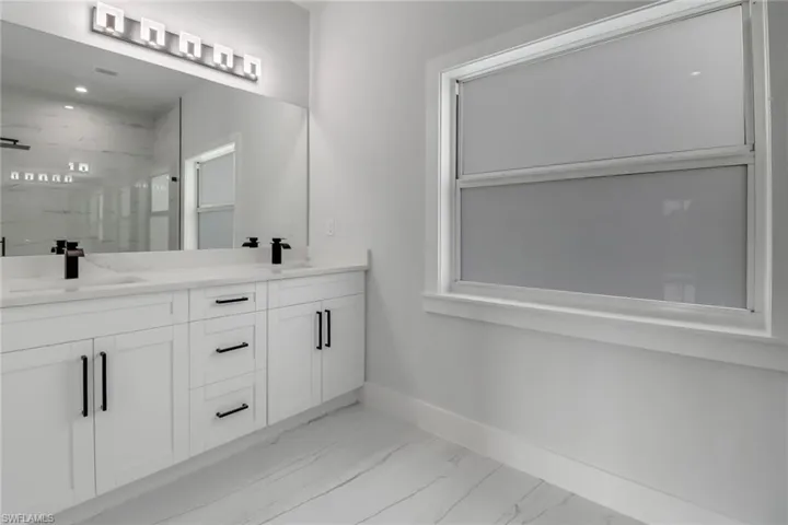Bathroom featuring tiled shower, hardwood / wood-style floors, and vanity
