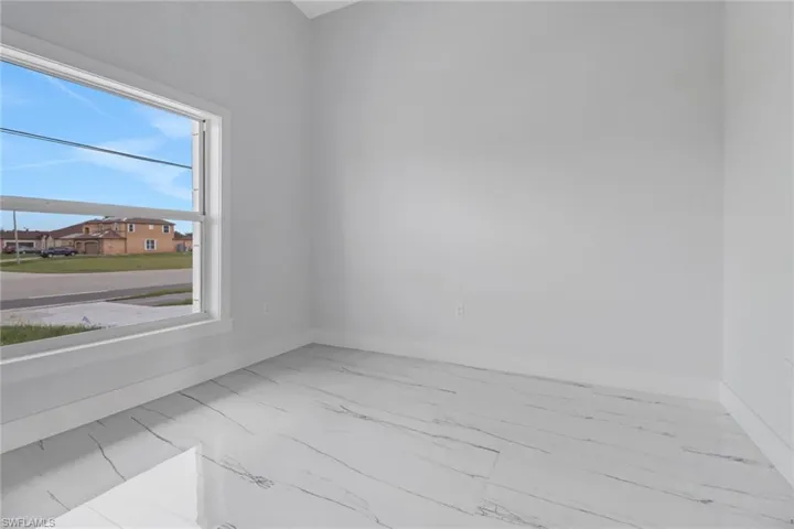 Tiled spare room with a healthy amount of sunlight