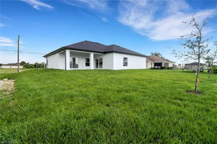 Back of property with a lawn