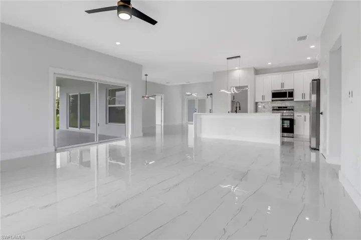 Unfurnished living room featuring ceiling fan and light tile patterned floors