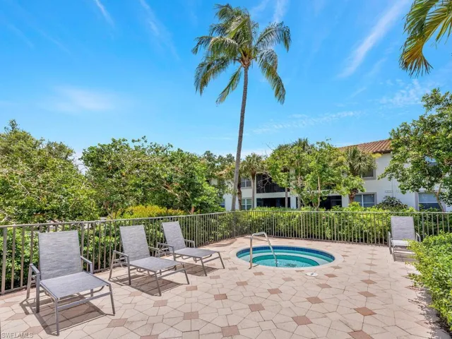 View of swimming pool featuring a community hot tub and a patio area