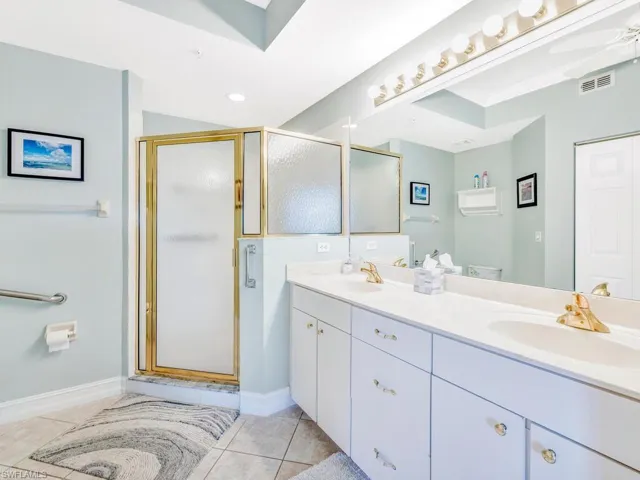 Bathroom with double vanity, tile floors, and shower