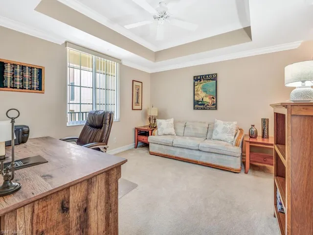 Office or 3rd bedroom area featuring ceiling fan, carpet, a tray ceiling, and crown molding
