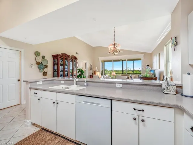 Kitchen with white cabinetry, tile flooring, and white appliances