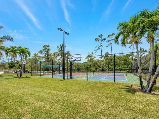 View of basketball court with tennis court and a lawn