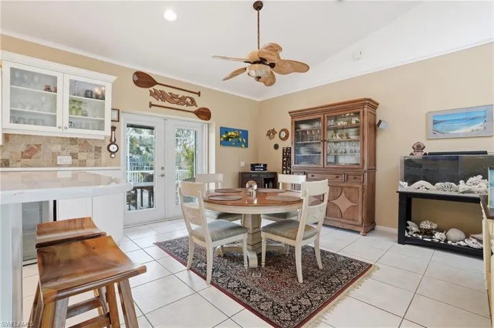 Dining area featuring french doors, light tile patterned floors, a ceiling fan, crown molding, and lofted ceiling