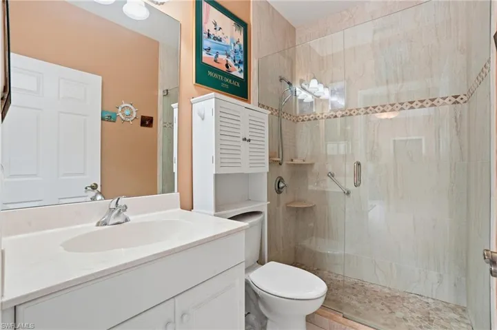 Full bath featuring vanity and a marble finish shower