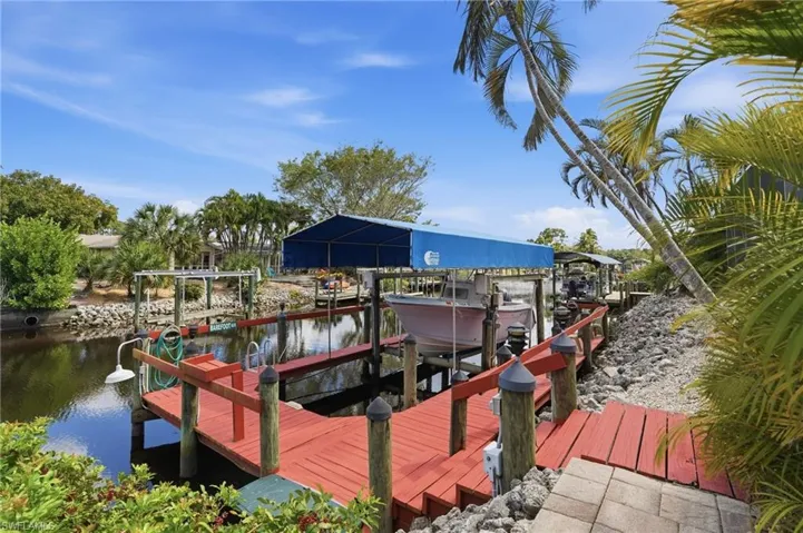 Dock featuring boat lift and a water view