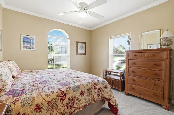 Bedroom featuring crown molding, light carpet, and a ceiling fan
