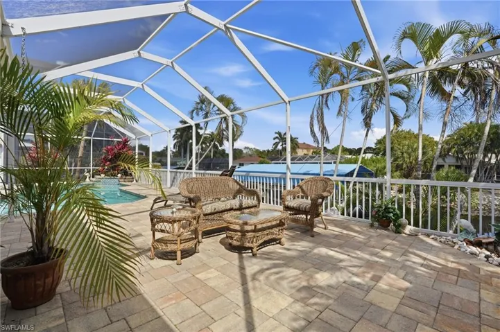 View of patio featuring glass enclosure, a sunroom, an outdoor pool, and outdoor lounge area