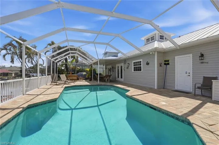 Swimming pool with a patio, glass enclosure, and a sunroom