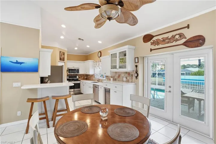 Dining room with french doors, light tile patterned floors, crown molding, ceiling fan, and recessed lighting