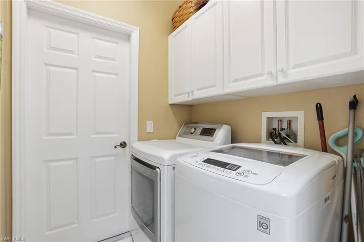 Laundry area featuring independent washer and dryer and cabinet space