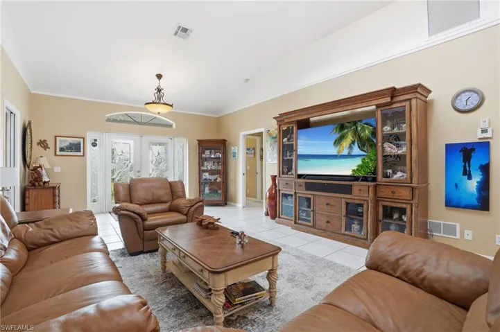 Living area featuring light tile patterned floors and vaulted ceiling