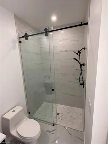 Bathroom featuring an enclosed shower and toilet