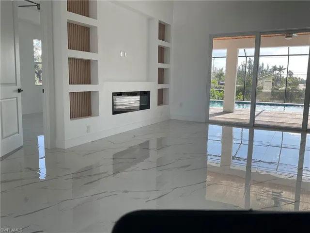 Unfurnished living room featuring built in shelves