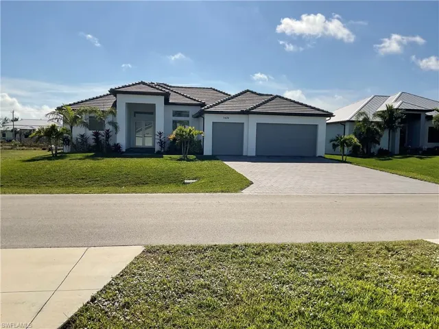 View of front of home with a garage and a front lawn