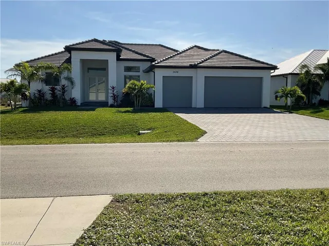 View of front of home with a front yard and a garage