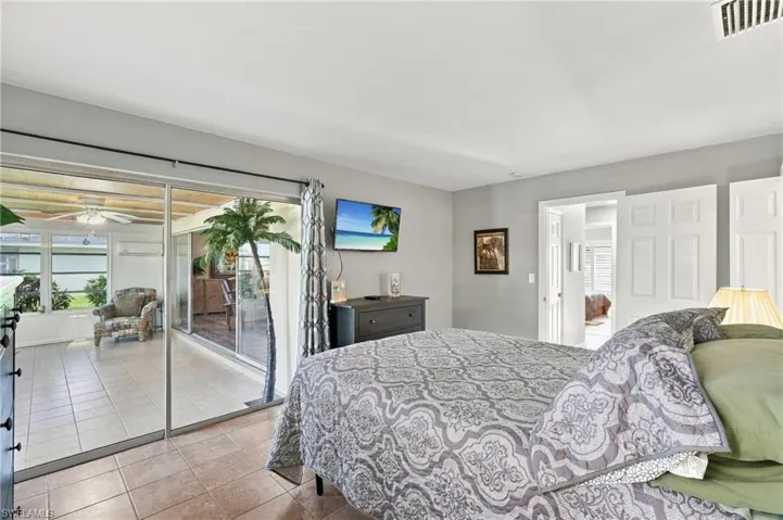 Sliding glass doors opening to a screened enclosure featuring tile flooring