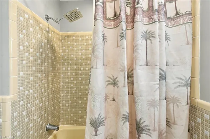 Shower with mosaic tile surround and a chrome rain showerhead