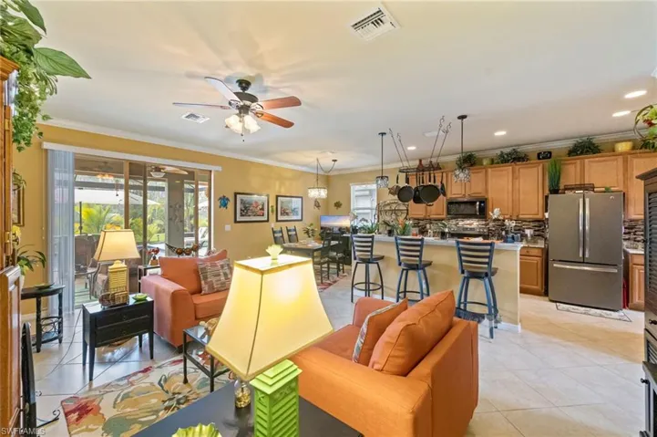Living area featuring ornamental molding, light tile patterned floors, a ceiling fan, and recessed lighting