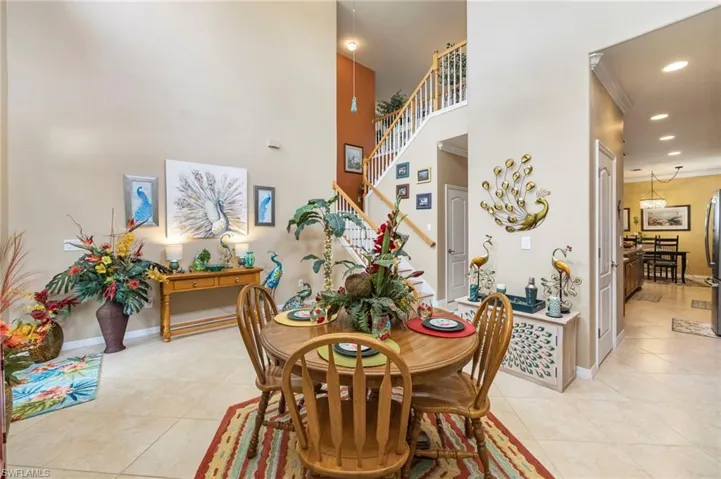 Dining room featuring recessed lighting, light tile patterned floors, crown molding, and a high ceiling
