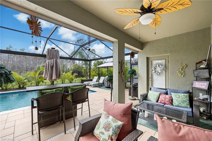 View of patio featuring a sunroom, glass enclosure, an outdoor pool, outdoor furniture, and a ceiling fan