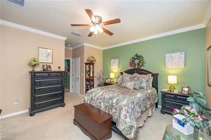 Bedroom featuring crown molding, ceiling fan, and light carpet