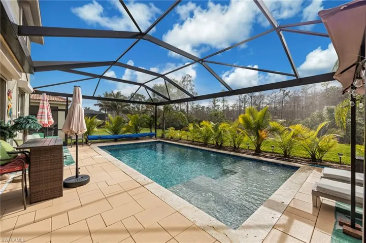 Outdoor pool featuring a sunroom, glass enclosure, a patio area, and outdoor dining area