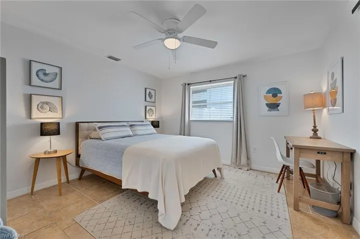 Master bedroom with a ceiling fan and light tile patterned floors