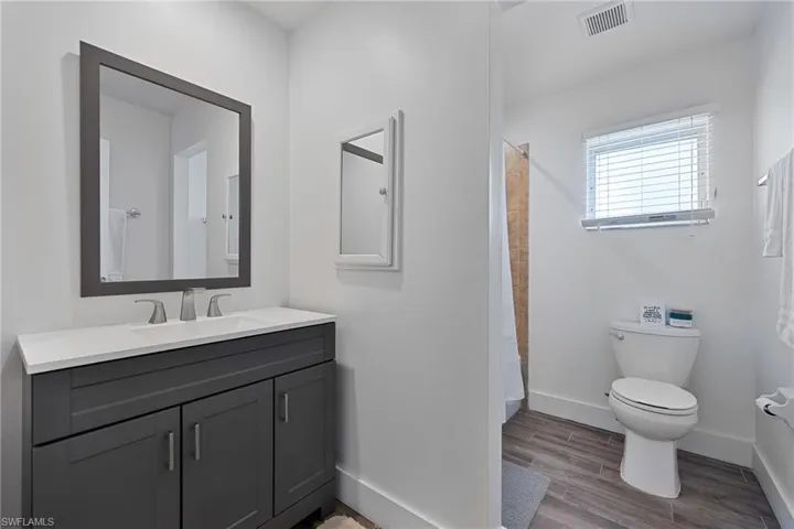 Guest bathroom with vanity, curtained tub/shower