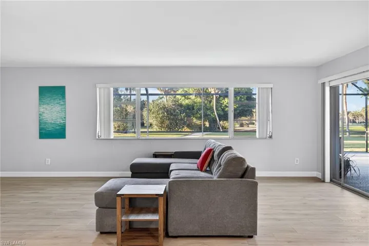 Spacious interior with light wood-finish flooring, white baseboards, and light gray walls
