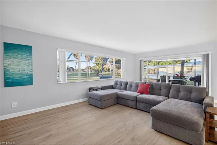 Bright living space featuring light wood-finish flooring, white baseboards, and neutral wall tones