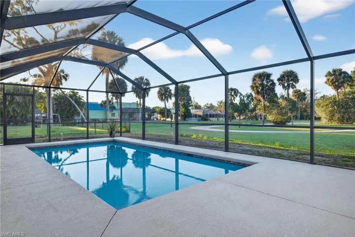 Screened outdoor pool with a rectangular shape and light blue interior