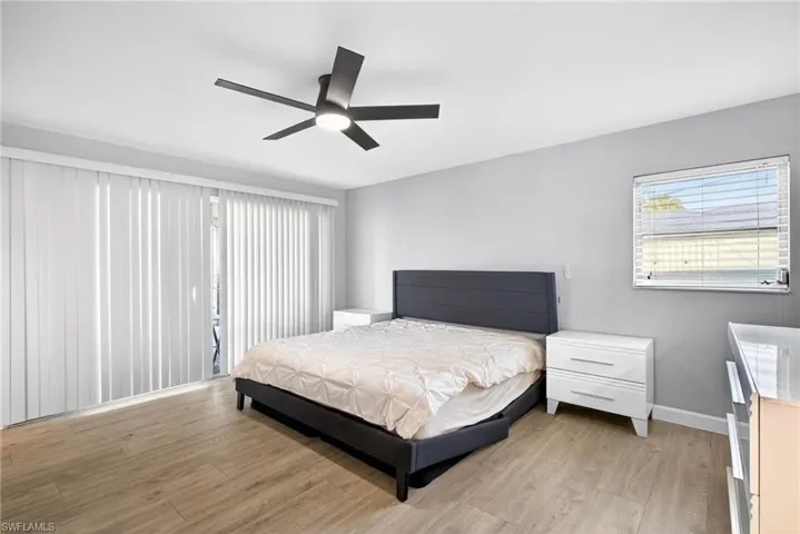 Room featuring wood-finish flooring, a contemporary ceiling fan, and light gray walls