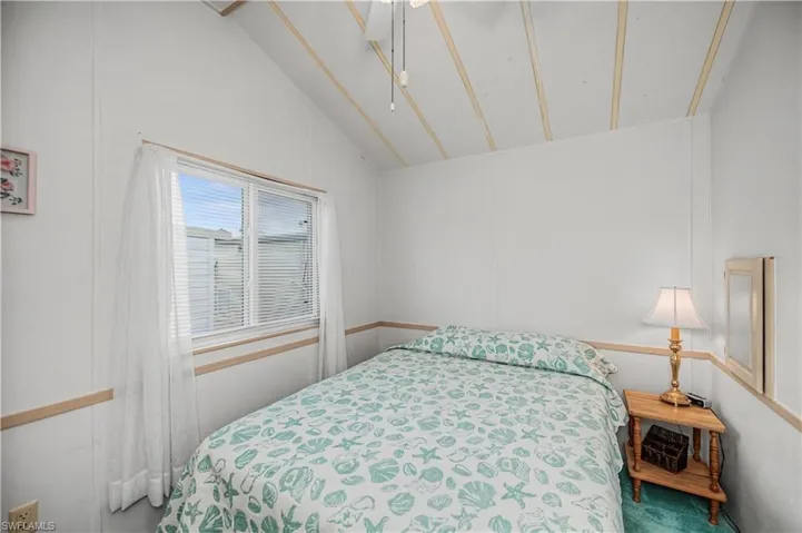Bedroom featuring carpet floors and vaulted ceiling
