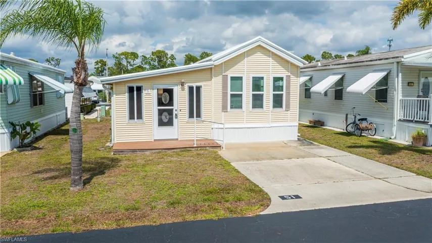 Manufactured / mobile home featuring a front yard and concrete driveway