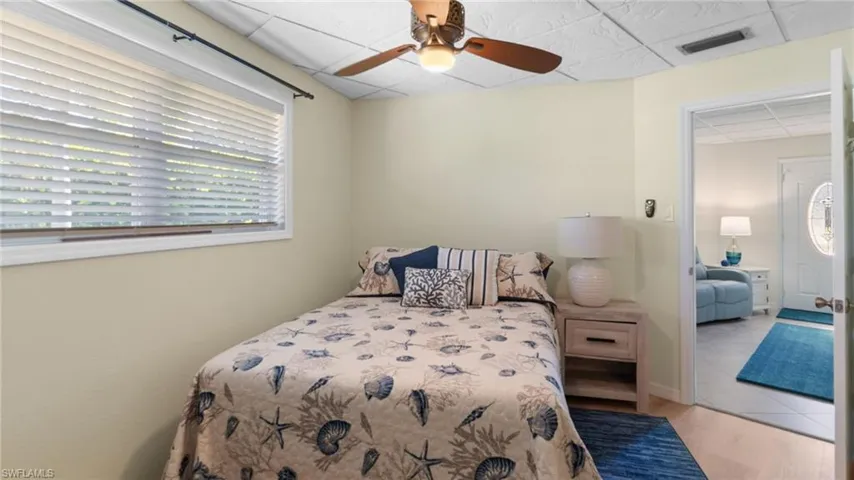 Bedroom with a paneled ceiling, a ceiling fan, and light wood finished floors