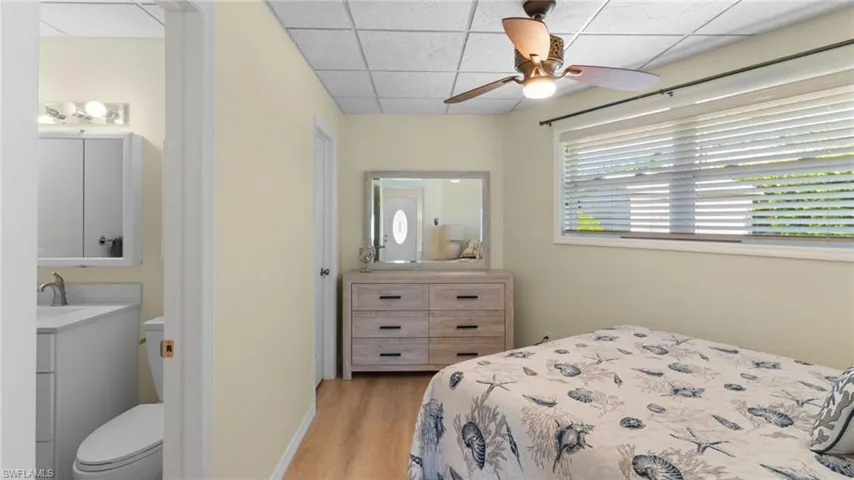 Bedroom featuring a paneled ceiling, light wood-style flooring, and a ceiling fan