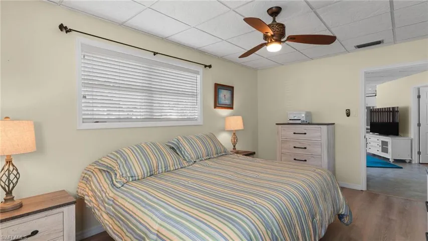 Bedroom featuring a paneled ceiling, ceiling fan, and wood finished floors