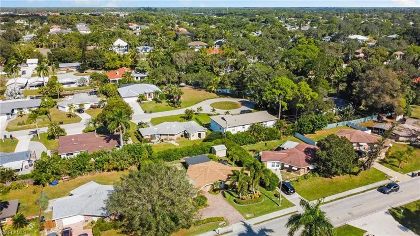 Aerial view of property and surrounding area featuring nearby suburban area