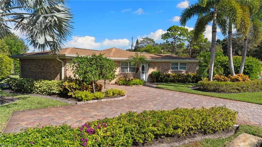 Single family, ranch-style house with brick siding and decorative driveway