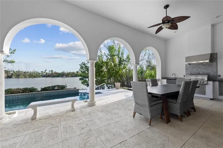 View of patio featuring grilling area, sink, a water view, and ceiling fan