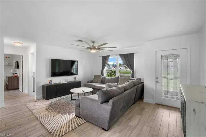 Living room with light hardwood / wood-style floors and ceiling fan