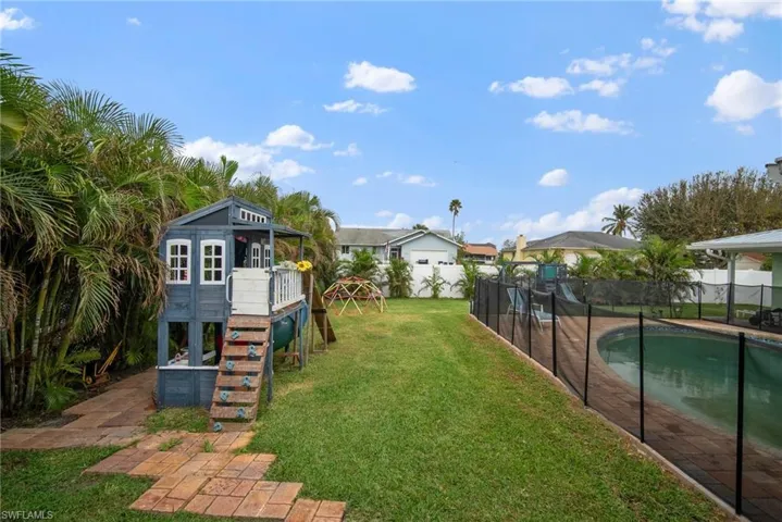 View of yard with a fenced in pool, a playground, and a patio area