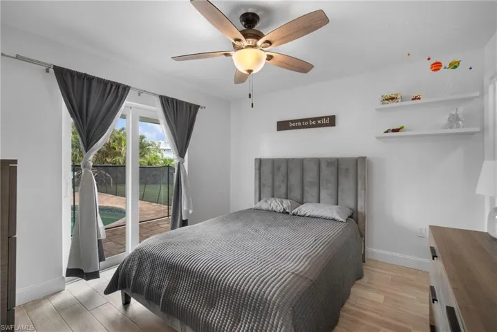 Bedroom featuring ceiling fan, light hardwood / wood-style floors, and access to exterior