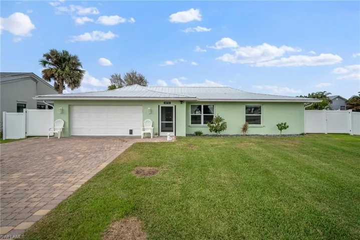 Ranch-style house featuring a garage and a front lawn